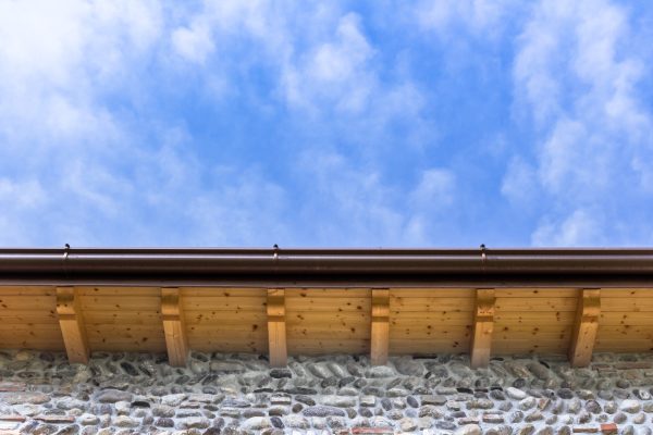Low angle view of new house with wooden roof and gutter